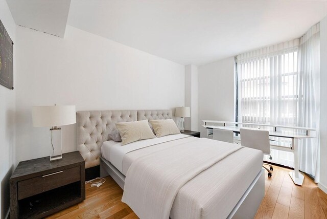 580 Washington St Unit 901, Boston, MA 02111 - bedroom with light wood finished floors and multiple windows