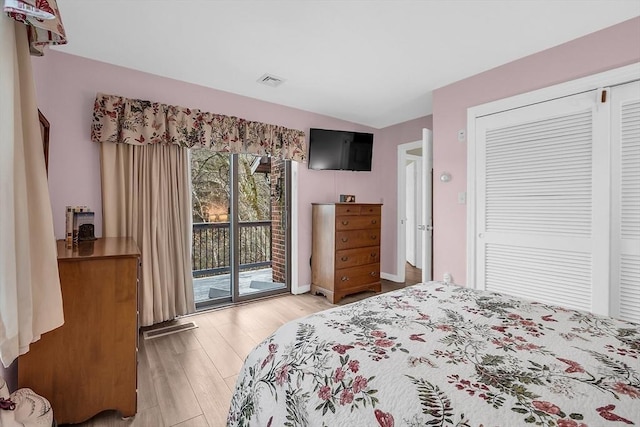 bedroom with wood-type flooring, access to outside, and a closet