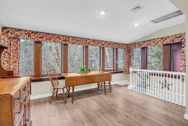 dining space featuring light wood-type flooring and lofted ceiling