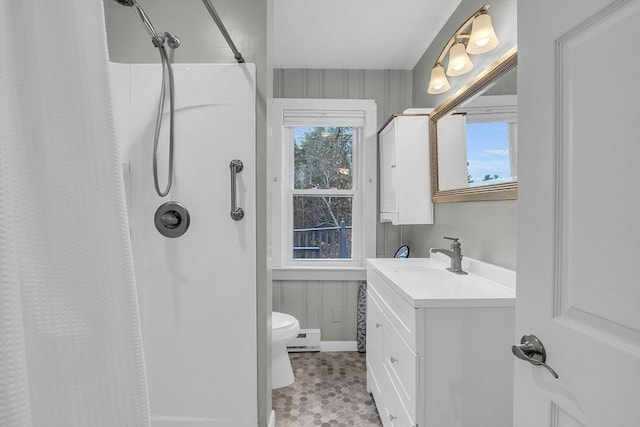 bathroom with a wealth of natural light, toilet, vanity, and walk in shower