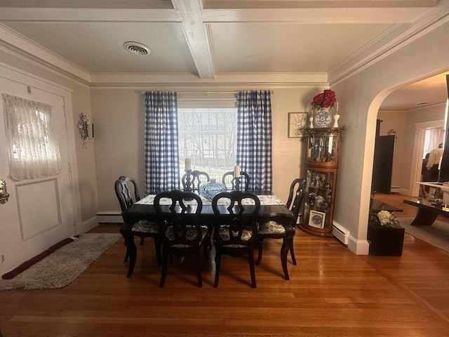 dining space featuring baseboard heating, wood-type flooring, and crown molding