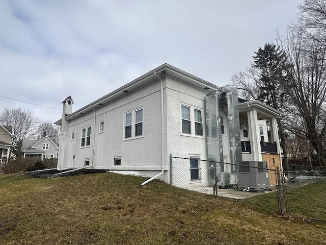 view of home's exterior with cooling unit and a yard