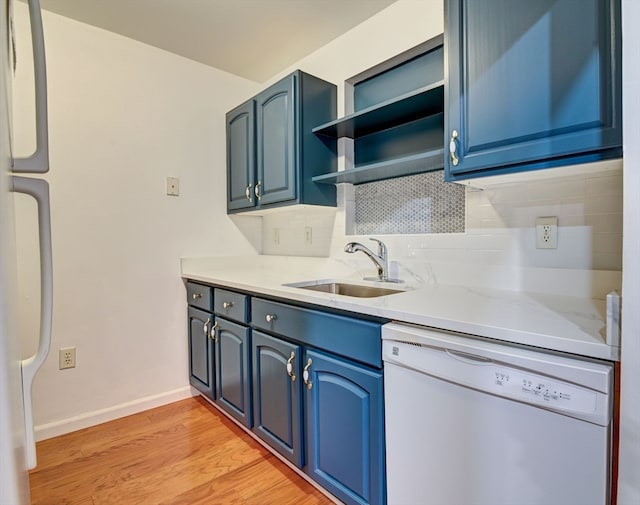 kitchen featuring blue cabinetry, white appliances, sink, and light hardwood / wood-style floors