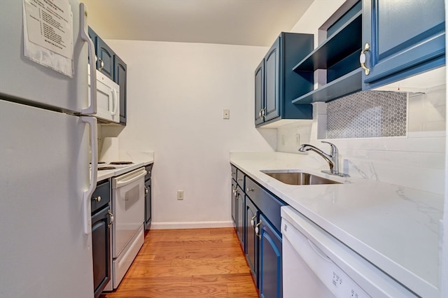 kitchen featuring sink, backsplash, white appliances, blue cabinetry, and light wood-type flooring