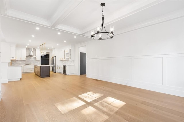 7 Bennett St, Natick, MA 01760 - unfurnished living room featuring a chandelier, a decorative wall, light wood-style flooring, crown molding, and beam ceiling