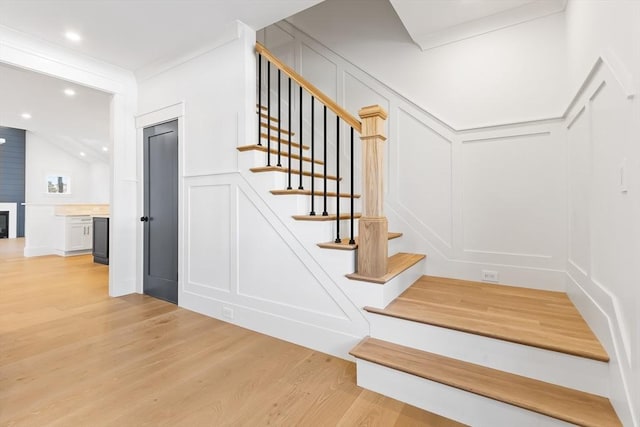 7 Bennett St, Natick, MA 01760 - stairs featuring a decorative wall, wood finished floors, crown molding, recessed lighting, and wainscoting