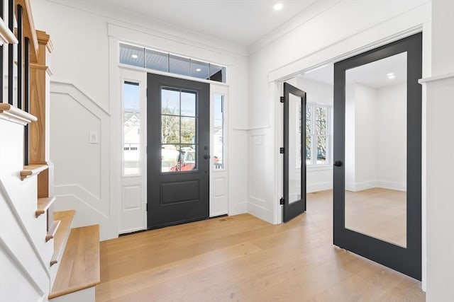 7 Bennett St, Natick, MA 01760 - foyer entrance with a decorative wall, light wood-type flooring, ornamental molding, stairway, and recessed lighting