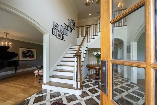 5 Copperbeech Cir, Westborough, MA 01581 - stairway featuring inlaid floor details, a chandelier, crown molding, baseboards, and arched walkways