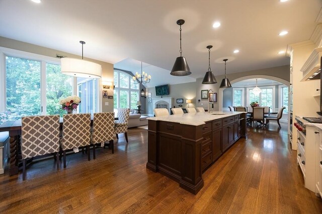5 Copperbeech Cir, Westborough, MA 01581 - kitchen featuring dark brown cabinets, arched walkways, dark wood-style flooring, open floor plan, and pendant lighting