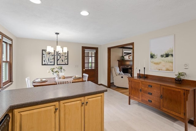 52 Diana Dr, Marlborough, MA 01752 - kitchen featuring light wood-style flooring, a chandelier, dark countertops, a fireplace, and decorative light fixtures