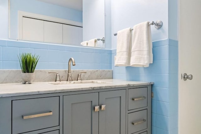 bathroom with vanity and tile walls