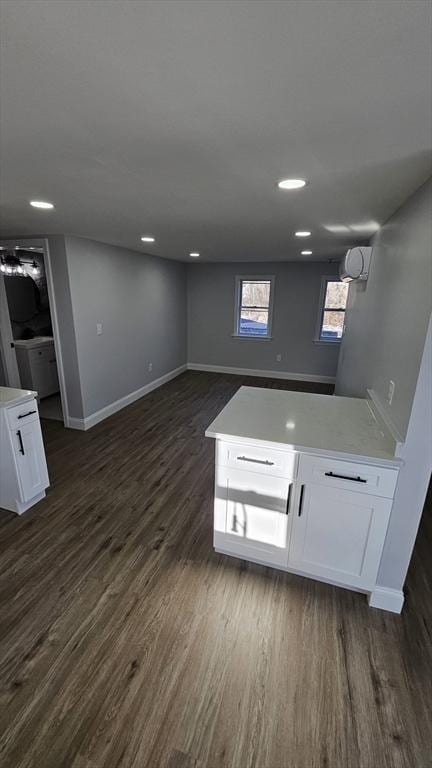 basement featuring a wall mounted air conditioner and dark hardwood / wood-style floors