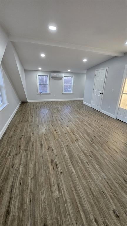 basement with hardwood / wood-style floors and a wall mounted air conditioner