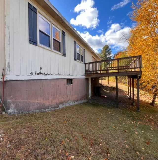 view of property exterior with a yard and a deck