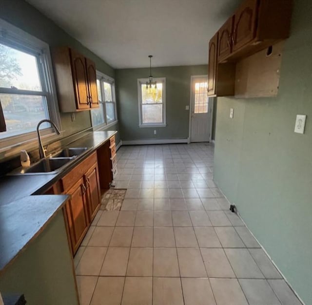 kitchen featuring decorative light fixtures, light tile patterned floors, sink, and baseboard heating