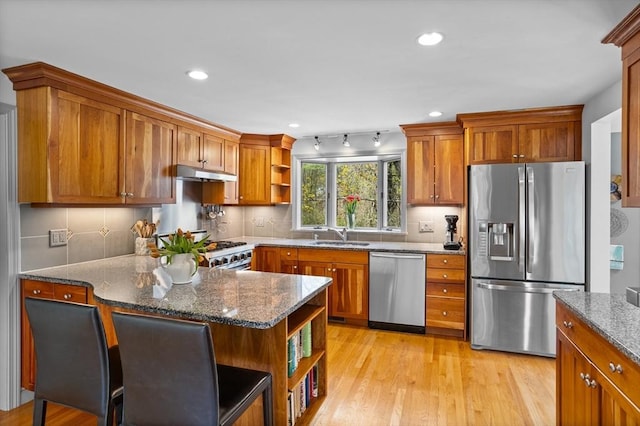 kitchen with open shelves, dark stone counters, appliances with stainless steel finishes, and under cabinet range hood