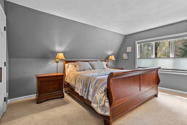 carpeted bedroom with baseboards and vaulted ceiling