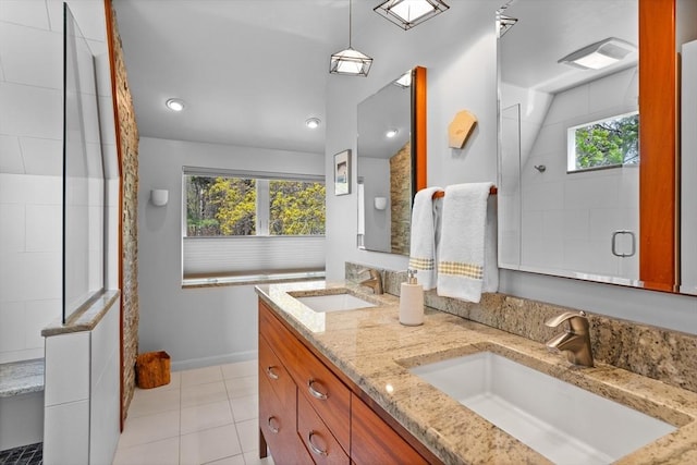 full bath with tile patterned flooring, a sink, a tile shower, and double vanity