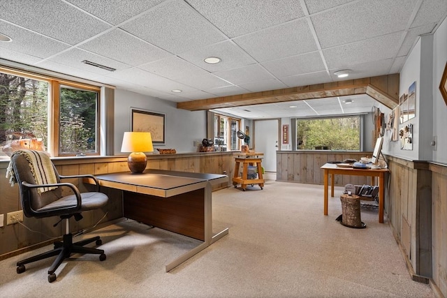 office with carpet flooring, wood walls, a drop ceiling, and visible vents