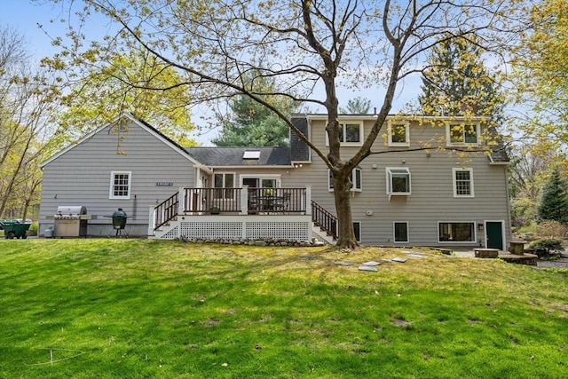rear view of house featuring a lawn, a deck, and stairs