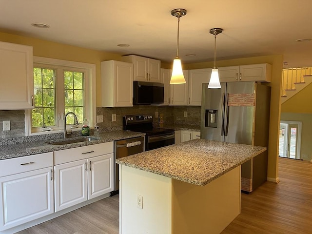 24A Outlook Dr Unit A, Worcester, MA 01602 - kitchen featuring appliances with stainless steel finishes, light wood finished floors, light stone counters, white cabinets, and backsplash