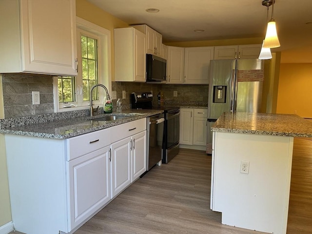 24A Outlook Dr Unit A, Worcester, MA 01602 - kitchen with appliances with stainless steel finishes, a kitchen island, light stone countertops, light wood finished floors, and white cabinets