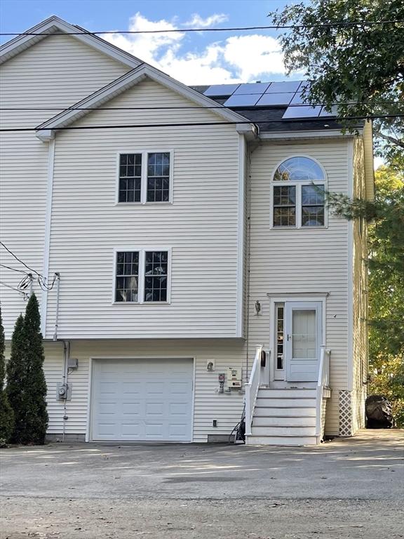 24A Outlook Dr Unit A, Worcester, MA 01602 - view of front of home with an attached garage, solar panels, and driveway