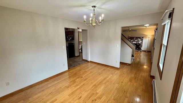 61 Bernice Ave, Leominster, MA 01453 - empty room with a chandelier, wood finished floors, stairs, a baseboard heating unit, and a ceiling fan