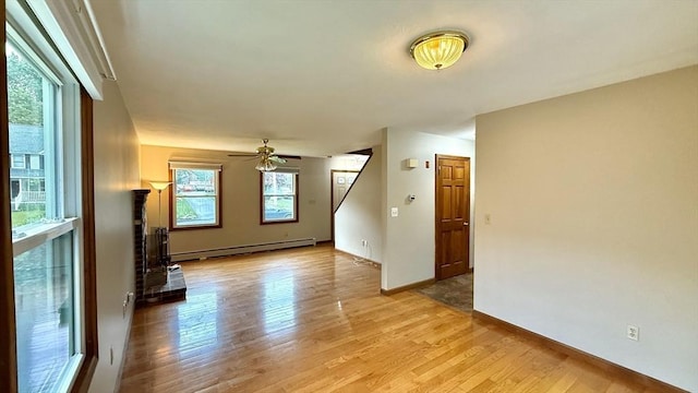 61 Bernice Ave, Leominster, MA 01453 - unfurnished living room with a baseboard radiator, light wood finished floors, a ceiling fan, and stairs