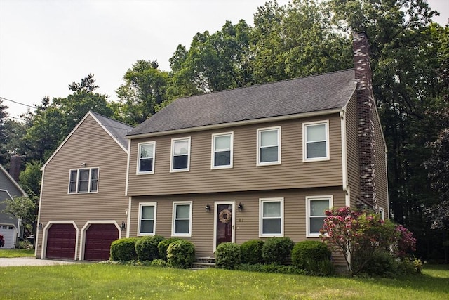 61 Bernice Ave, Leominster, MA 01453 - colonial house featuring a chimney, an attached garage, a front yard, and driveway