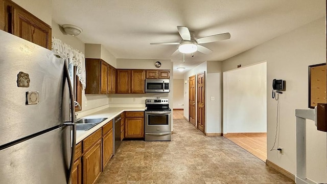 61 Bernice Ave, Leominster, MA 01453 - kitchen with appliances with stainless steel finishes, a ceiling fan, brown cabinetry, and light countertops