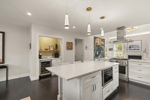 16 Primrose Ln Unit 16, Ipswich, MA 01938 - kitchen with appliances with stainless steel finishes, island range hood, wine cooler, light countertops, and white cabinets