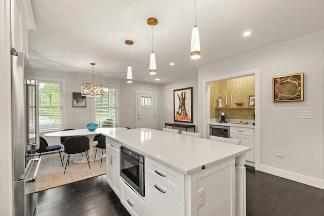 16 Primrose Ln Unit 16, Ipswich, MA 01938 - kitchen with appliances with stainless steel finishes, dark wood finished floors, light countertops, white cabinetry, and a kitchen island