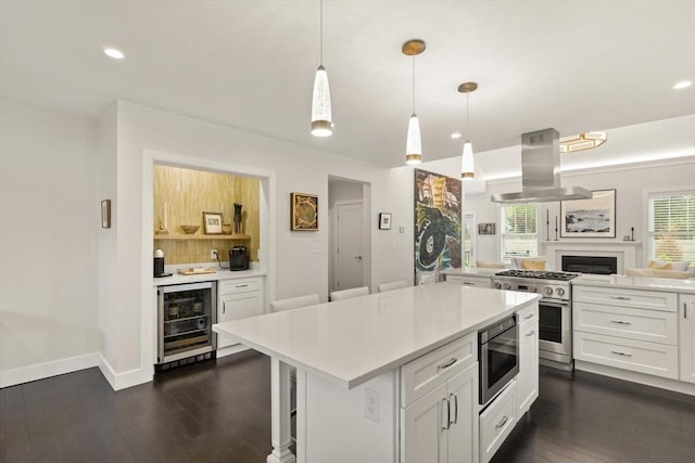 16 Primrose Ln Unit 16, Ipswich, MA 01938 - kitchen featuring beverage cooler, island exhaust hood, appliances with stainless steel finishes, light countertops, and white cabinetry