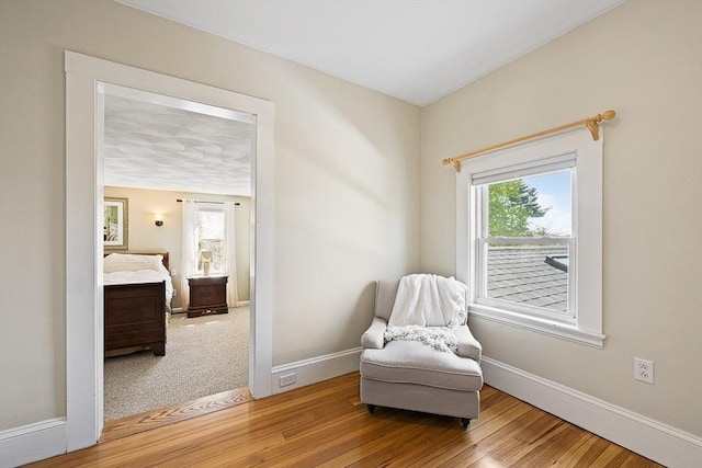 living area featuring baseboards and wood finished floors