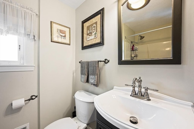 bathroom featuring vanity, toilet, and a shower