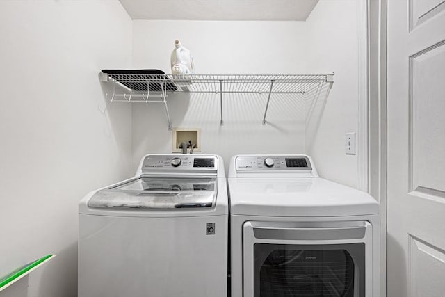 washroom featuring separate washer and dryer and laundry area