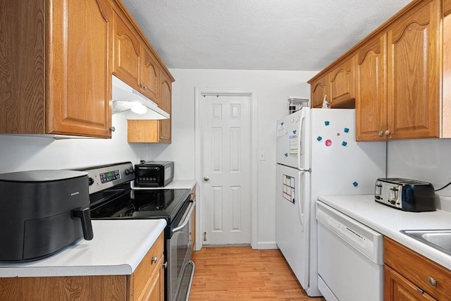 kitchen featuring white dishwasher, black microwave, stainless steel range with electric stovetop, brown cabinetry, and under cabinet range hood