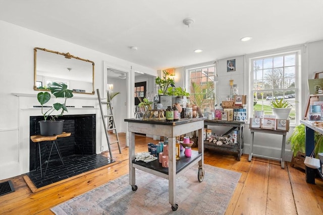 interior space with wood-type flooring, recessed lighting, visible vents, and a fireplace