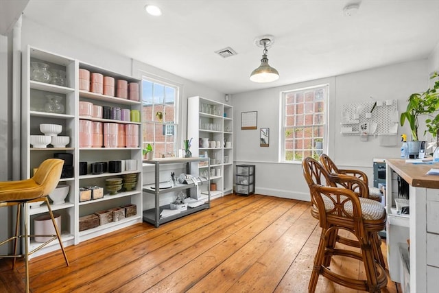 living area featuring baseboards, visible vents, and hardwood / wood-style flooring
