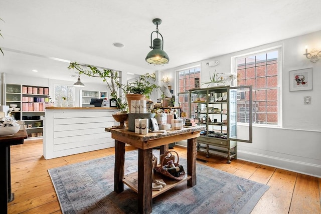 office area featuring baseboards, wood-type flooring, and plenty of natural light