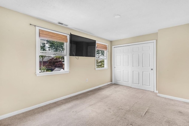 19 Doane Unit 1, Lowell, MA 01851 - unfurnished bedroom featuring carpet floors, baseboards, and a closet