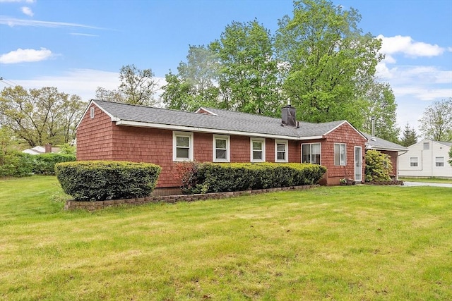 ranch-style home with a chimney and a front lawn