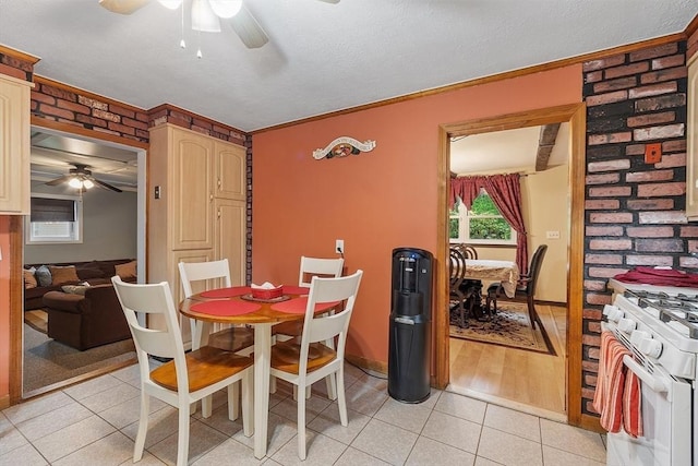 dining area with a ceiling fan, light tile patterned floors, ornamental molding, and baseboards