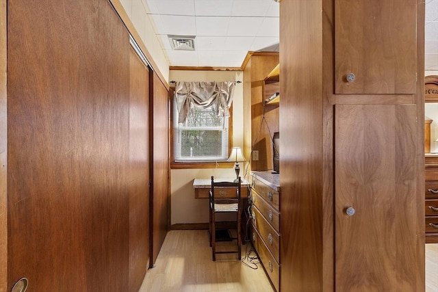 bathroom with wood finished floors, baseboards, and a drop ceiling