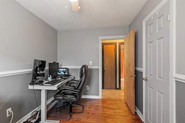 office with wood finished floors, baseboards, and a textured ceiling