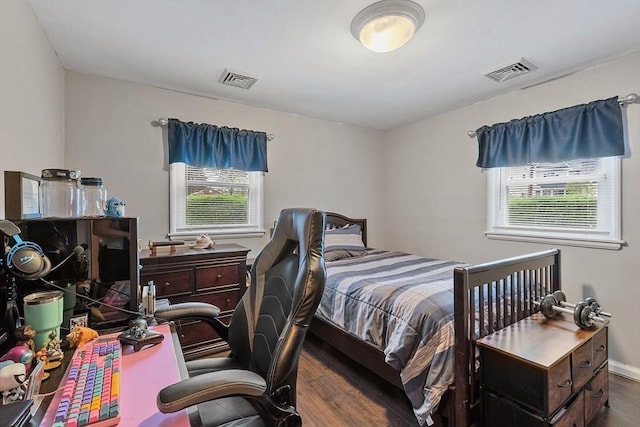 bedroom featuring multiple windows, wood finished floors, and an office area