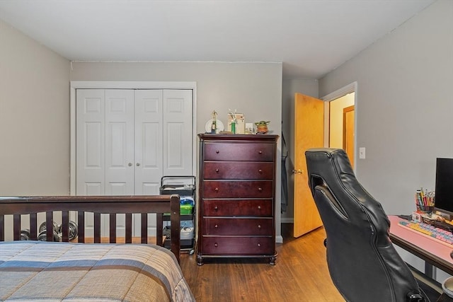 bedroom with wood finished floors, a closet, and an office area