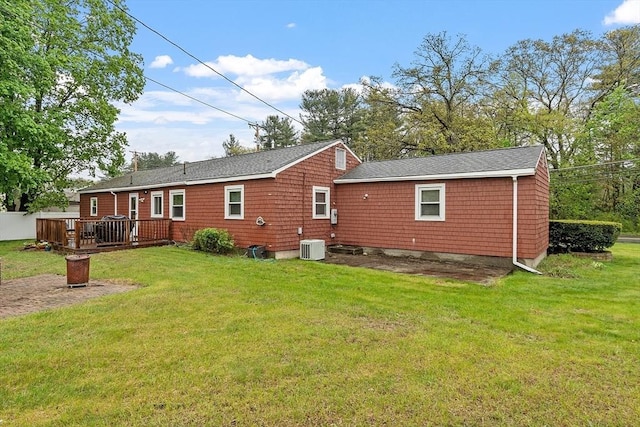 rear view of property featuring central AC unit, a deck, and a yard