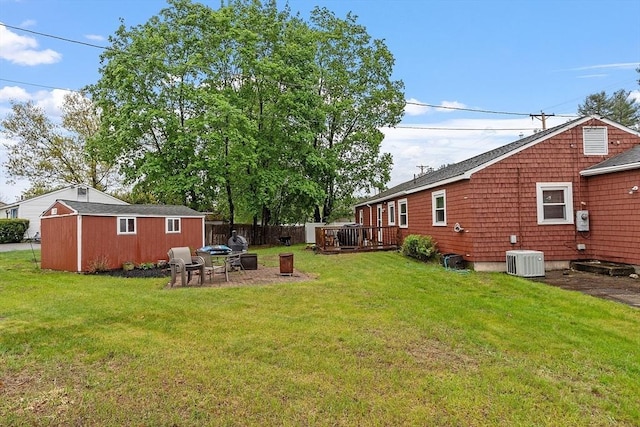 view of yard featuring cooling unit, a deck, and an outdoor fire pit